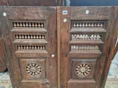 A PAIR OF OAK CUPBOARD DOORS, EACH PIERCED WITH THREE BANDS OF BALUSTRADES ABOVE BALUSTERS IN