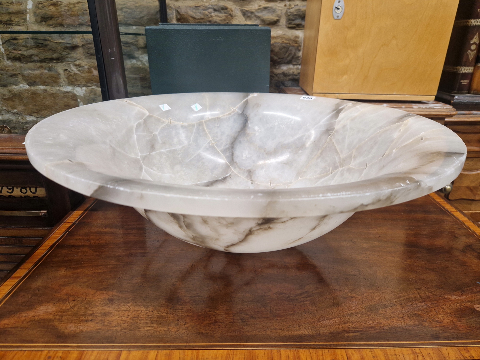 A MOTTLED GREY ALABASTER CEILING DISH, THE BOWL SHAPE WITH SUSPENSION HOLES IN THE FLATTENED RIM.