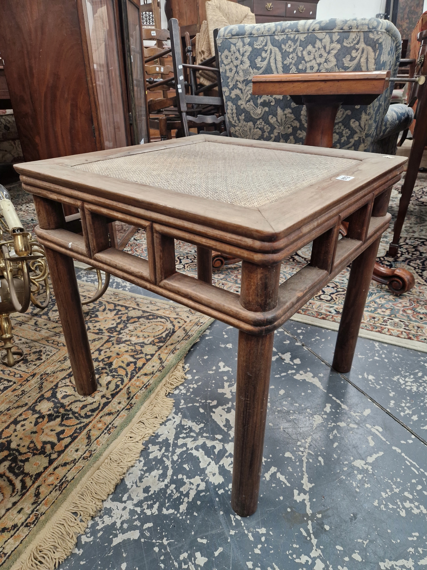 A CHINESE HARDWOOD TABLE, THE CANE INSET TOP ABOVE AN OPEN WORK APRON AND FOUR CYLINDRICAL LEGS.   W - Image 3 of 10