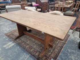A SMALL OAK REFECTORY TABLE ON TRESTLE END SUPPORTS.