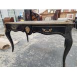 A BOULLE WRITING TABLE WITH A LEATHER INSET TOP AND TWO DRAWERS FLANKING AN APPLIED MASK TO ONE
