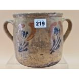 A TWO HANDLED BROWN POTTERY TWO HANDLED JAR PAINTED WITH STYLISED FLOWERS, POSSIBLY EARLY 20th C.