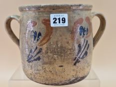 A TWO HANDLED BROWN POTTERY TWO HANDLED JAR PAINTED WITH STYLISED FLOWERS, POSSIBLY EARLY 20th C.