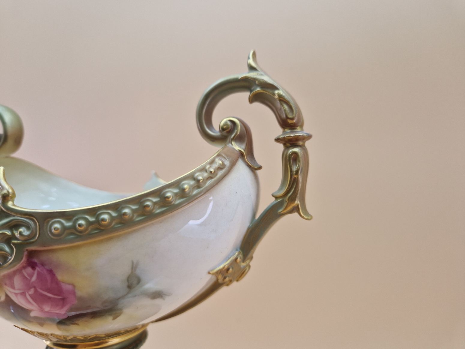 A 1908 ROYAL WORCESTER TWO HANDLED FOOTED NAVETTE SHAPED BOWL PAINTED WITH ROSES BETWEEN GILT - Image 2 of 7