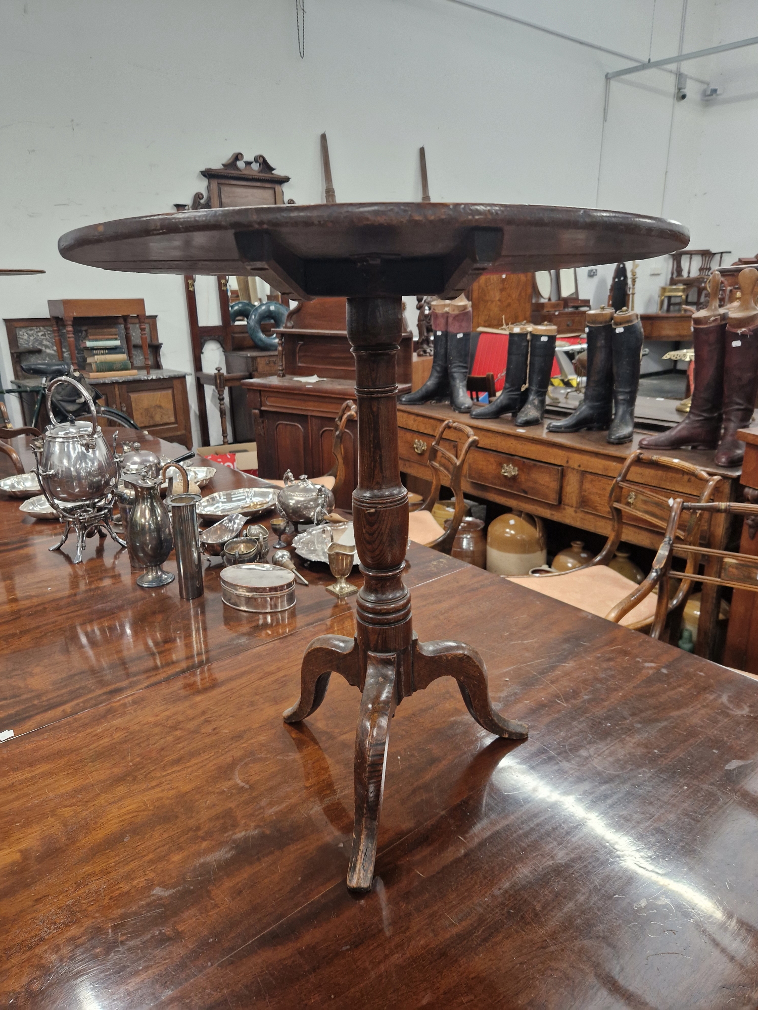 AN OAK TRIPOD TABLE WITH A CIRCULAR TILT TOP ONA BLUSTER COLUMN