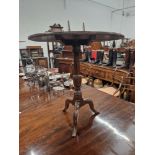 AN OAK TRIPOD TABLE WITH A CIRCULAR TILT TOP ONA BLUSTER COLUMN