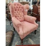 A MAHOGANY WING BACK ARMCHAIR BUTTON UPHOLSTERED IN PINK