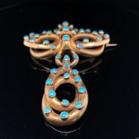 A VICTORIAN TURQUOISE SET LOVERS KNOT BROOCH WITH SERPENTINE STYLE ARTICULATED DROP AND MEMORIAL