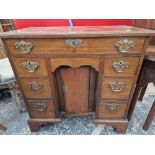 A GEORGE III MAHOGANY KNEEHOLE DESK, THE RECESSED CENTRAL DOOR FLANKED BY BANKS OF THREE DRAWERS