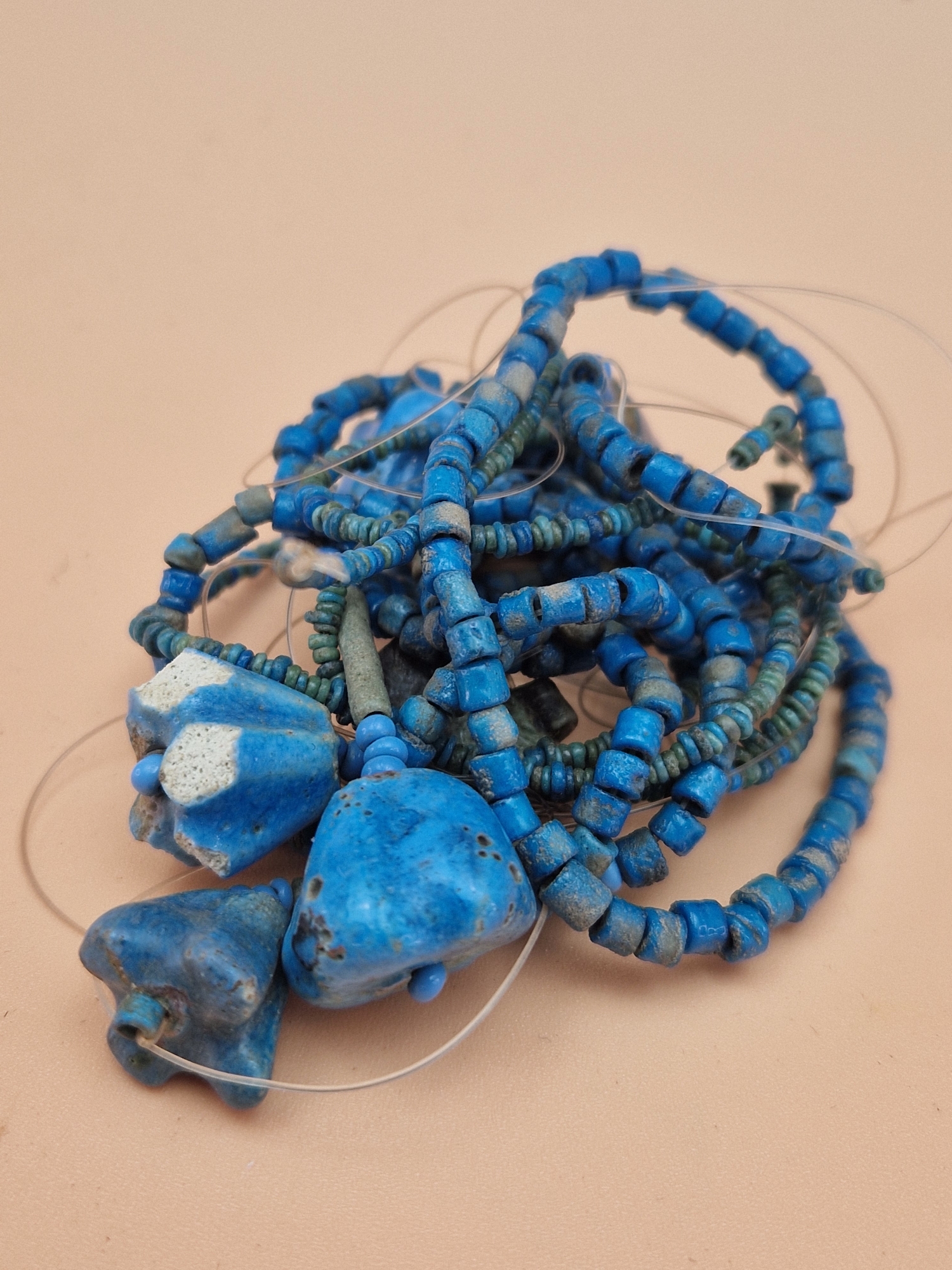 A COLLECTION OF EGYPTIAN BLUE AND GREY POTTERY BEAD WORKS