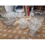 SIX CLEAR GLASS FOOTED BOWLS TOGETHER WITH A CUT GLASS OVAL BOWL AND STAND WITH FAN SHAPED HANDLES