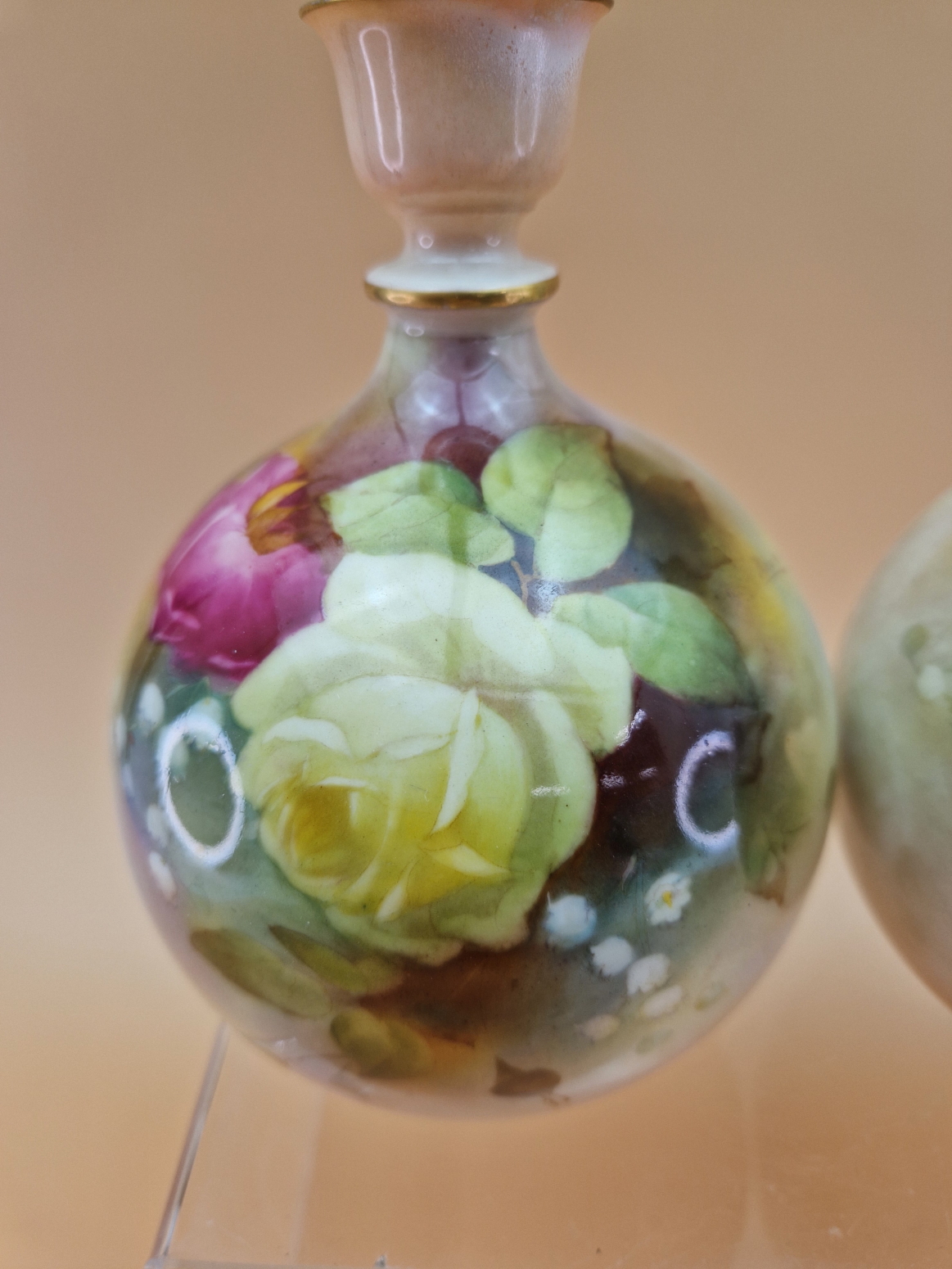 A PAIR OF 1911 ROYAL WORCESTER VASES, THE COMPRESSED SPHERICAL BODIES PAINTED WITH ROSES. H 15.5cms. - Image 2 of 5