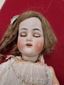 A KAMMER AND REINHART 70 BISQUE HEADED DOLL WITH SLEEPING EYES AND OPEN MOUTH. H 70cms.