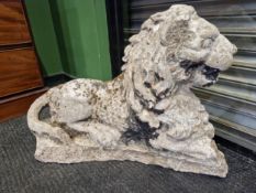 AN ANTIQUE RECONSTITUTED STONE FIGURE OF A RECUMBENT LION.