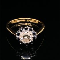 A DIAMOND AND SAPPHIRE ROUND CLUSTER RING. THE CENTRE DIAMOND A ROUND BRILLIANT CUT, ASSESSED