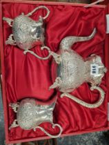 A RED CASED GERMAN SILVER THREE PIECE TEA SET, EACH PIECE CHASED WITH FLOWERS