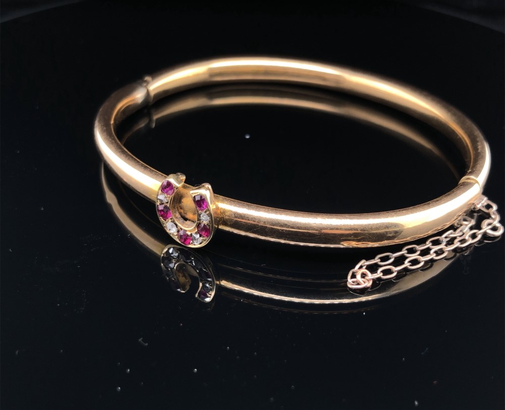 AN ANTIQUE BANGLE SET WITH A RUBY AND DIAMOND HORSESHOE. THE HINGED BANGLE UNHALLMARKED, ASSESSED AS - Image 2 of 8