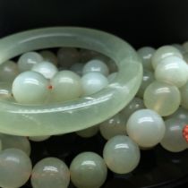 AN GREEN HARDSTONE EASTERN ROW OF CONTINUIOUS BEADS AND A SIMILAR BANGLE. BEAD LENGTH 161cms.