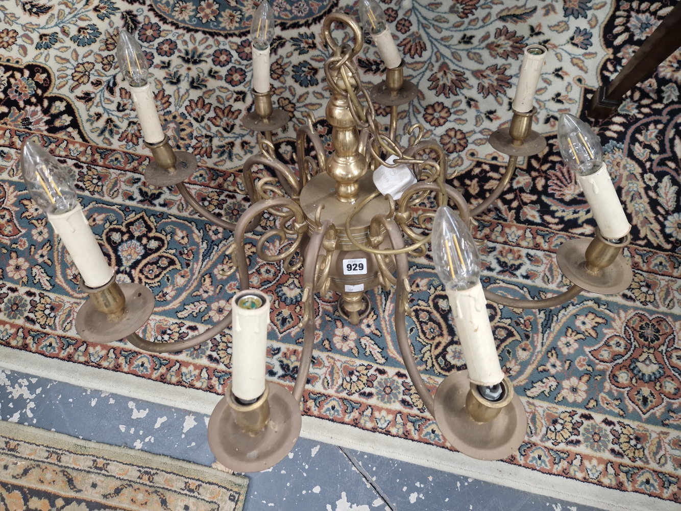 A BRASS EIGHT CANDLE LIGHT CHANDELIER, THE BRANCHES SCROLLING FROM A CENTRAL COLUMN