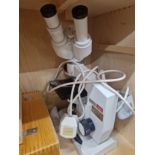 A CASED LOMO BINOCULAR MICROSCOPE WITH AN ELECTRIC LIGHT SOURCE AND SOME ACCESSORIES AND
