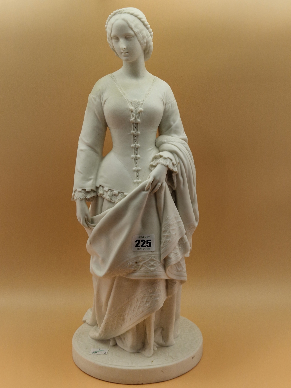 A MINTON PARIAN FIGURE OF A VICTORIAN LADY STANDING ON A CIRCULAR CARPET MOULDED BASE HOLDING UP A