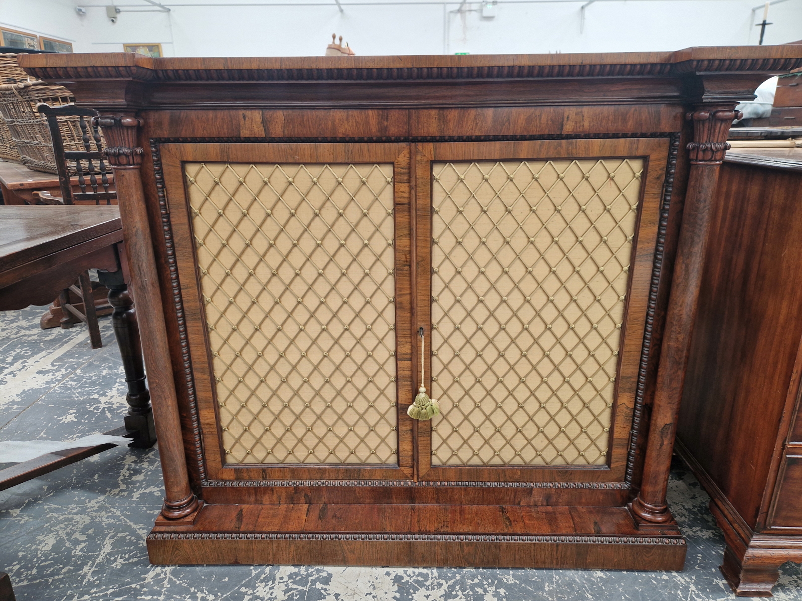 A VICTORIAN ROSEWOOD SIDE CABINET WITH COLUMNS FLANKING THE GRILLED DOORS, EGG AND DART BANDS