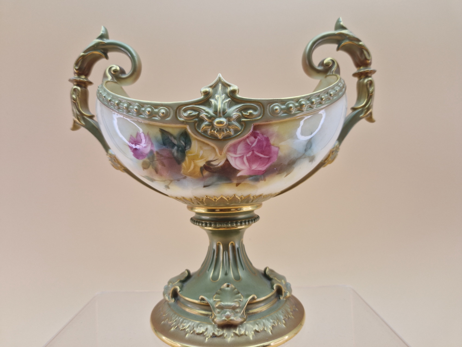 A 1908 ROYAL WORCESTER TWO HANDLED FOOTED NAVETTE SHAPED BOWL PAINTED WITH ROSES BETWEEN GILT