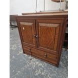 AN ARTS AND CRAFTS WALNUT SMALL CABINET WITH TWO DRAWER BELOW DOORS.