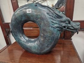 A BRONZE SCULPTURE OF A DRAGON WITH A CIRCULAR BODY. H 39cms.