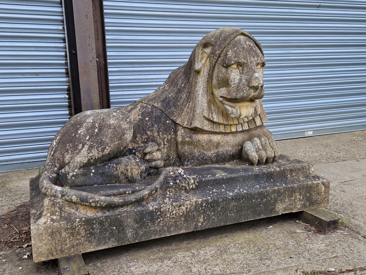 AN IMPRESSIVE PAIR OF RECONSTITUTED STONE ART DECO STYLISED RECUMBENT LIONS.