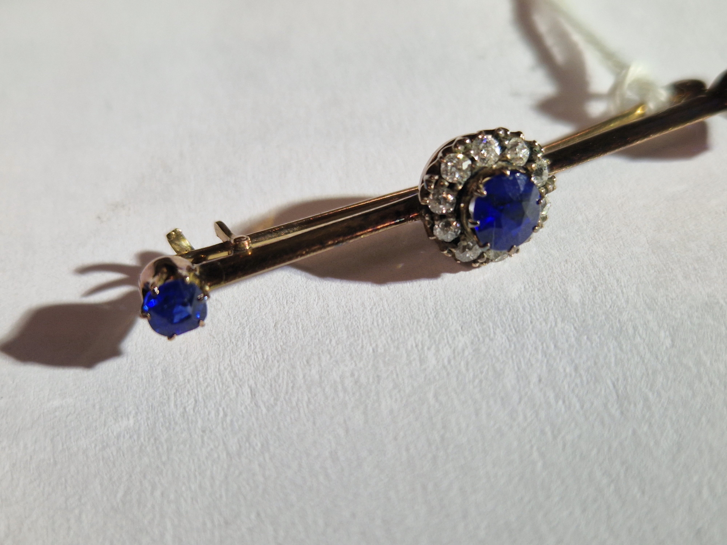 AN ANTIQUE SAPPHIRE AND DIAMOND BRA BROOCH. UNHALLMARKED, ASSESSED AS 9ct GOLD. LENGTH 4.6cms. - Image 4 of 7