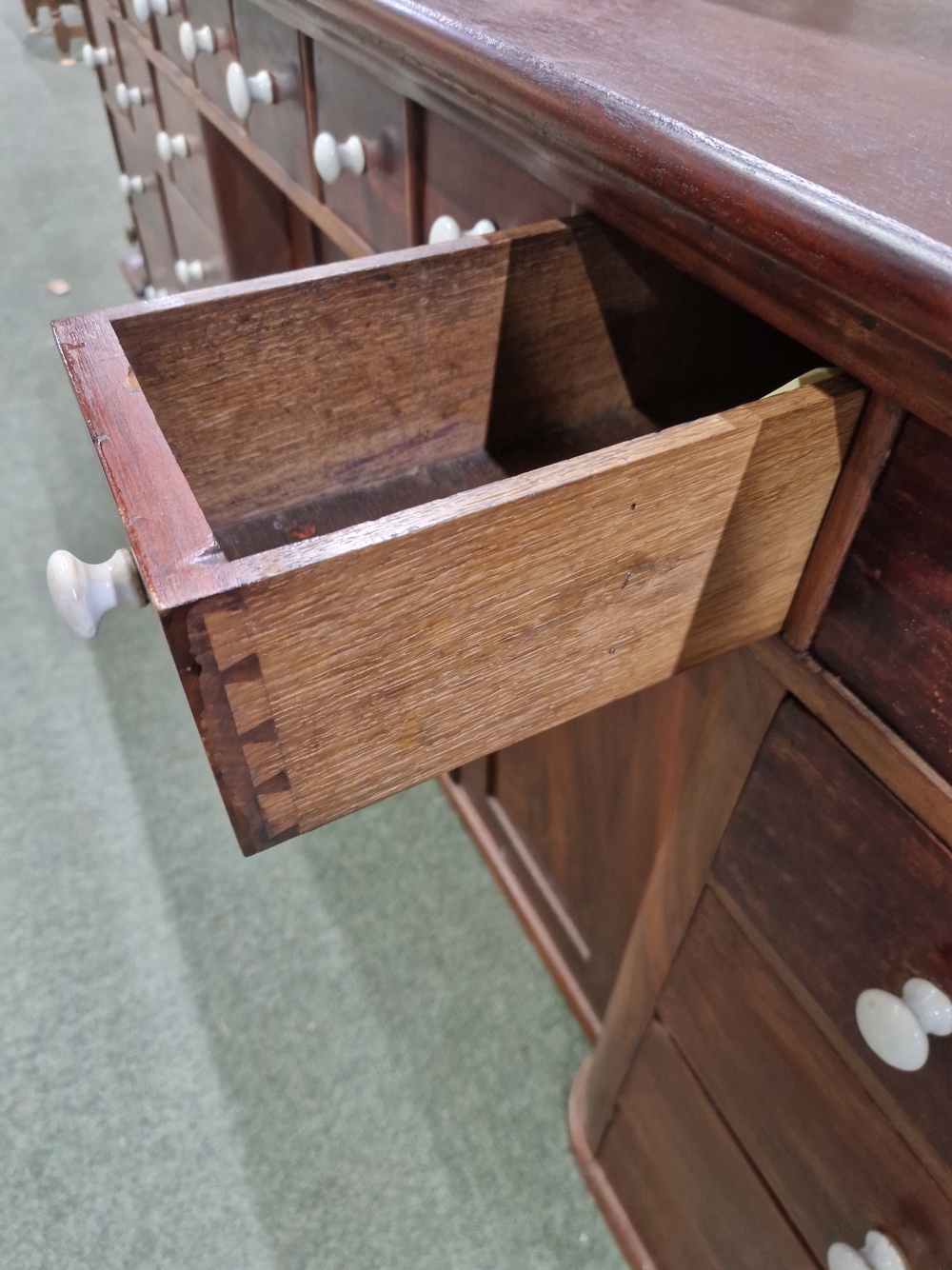 A MAHOGANY SHOP COUNTER FITTED WITH MULTIPLE DRAWERS AND CUPBOARDS EACH WITH WHITE CERAMIC KNOB - Image 18 of 23