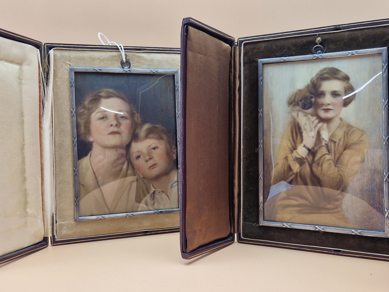 TWO PRE WWII EASEL BACKED LEATHER CASED OVER PAINTED PHOTOGRAPHIC MINIATURES OF A LADY, ONE