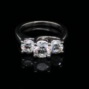 A THREE STONE DIAMOND TRILOGY RING. THE CENTRE DIAMOND APPROXIMATELY 1.02cts, THE TWO OUTER DIAMONDS