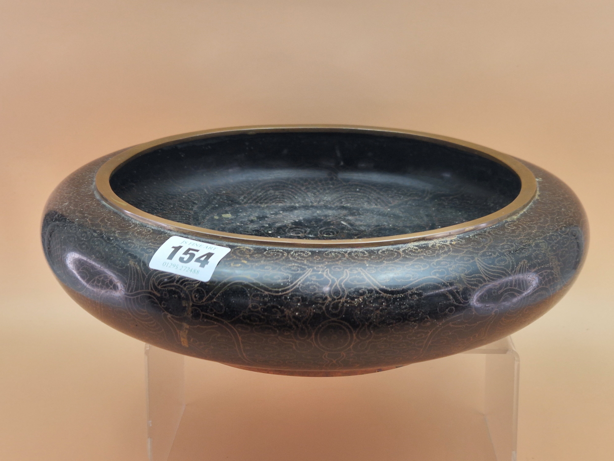 A CHINESE BLACK CLOISONNE SHALLOW BOWL, THE INTERIOR WORKED WITH A DRAGON AND FLAMING PEARL. Dia.