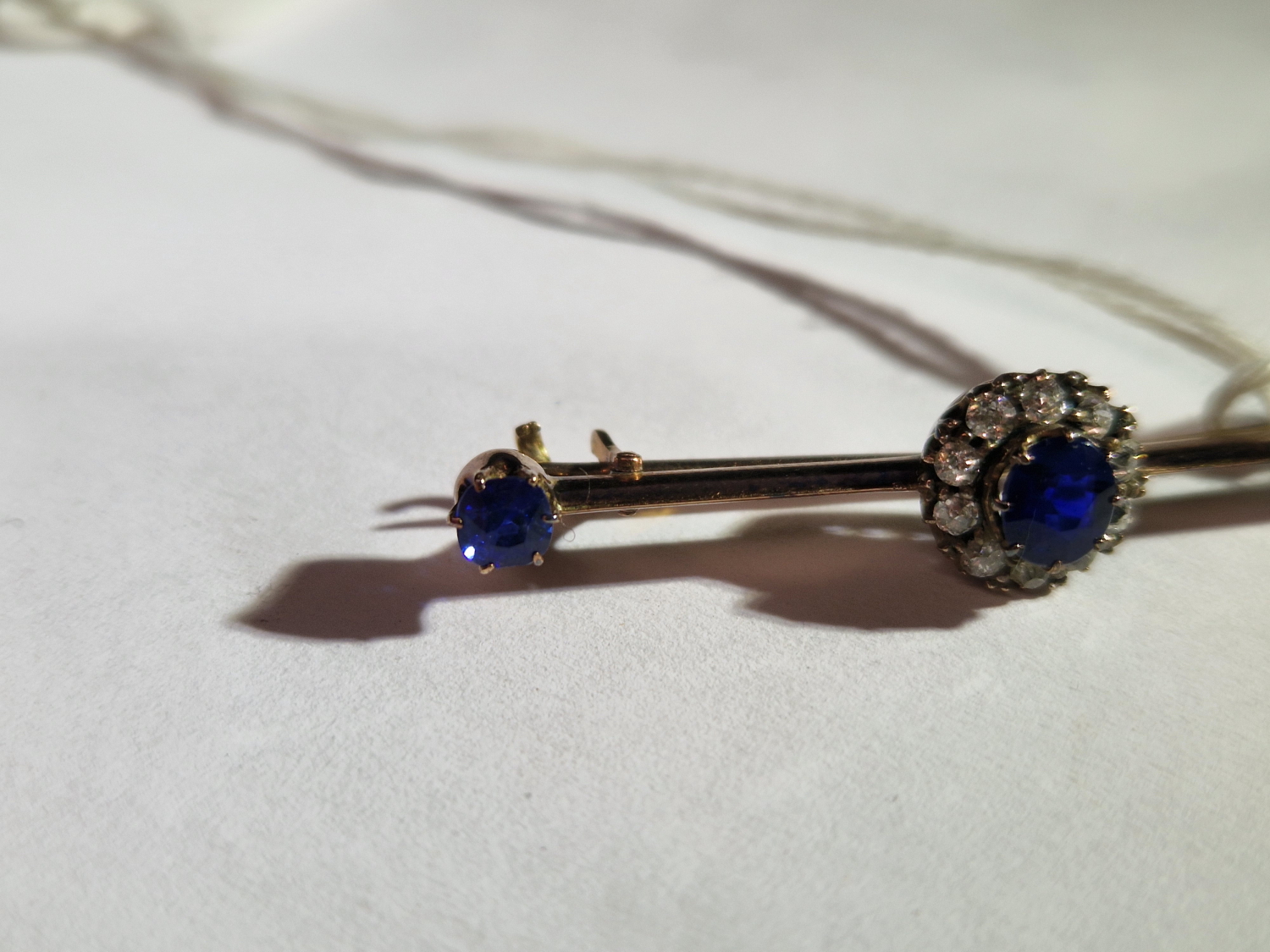 AN ANTIQUE SAPPHIRE AND DIAMOND BRA BROOCH. UNHALLMARKED, ASSESSED AS 9ct GOLD. LENGTH 4.6cms. - Image 6 of 7