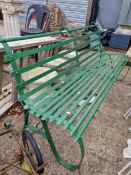 A 19TH CENTURY GREEN PAINTED IRON GARDEN BENCH ON SCROLL SUPPORTS.