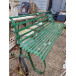 A 19TH CENTURY GREEN PAINTED IRON GARDEN BENCH ON SCROLL SUPPORTS.