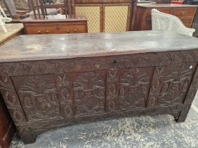 AN ANTIQUE OAK COFFER WITH THE FOUR PANELS TO THE FRONT CARVED WITH FOLIAGE.   W 149 x D 59 x H
