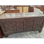 AN ANTIQUE OAK COFFER WITH THE FOUR PANELS TO THE FRONT CARVED WITH FOLIAGE.   W 149 x D 59 x H