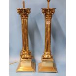 A PAIR OF BRASS COLUMN LAMPS WITH CORINTHIAN CAPITALS AND STEPPED SQUARE FEET. H 66cms.