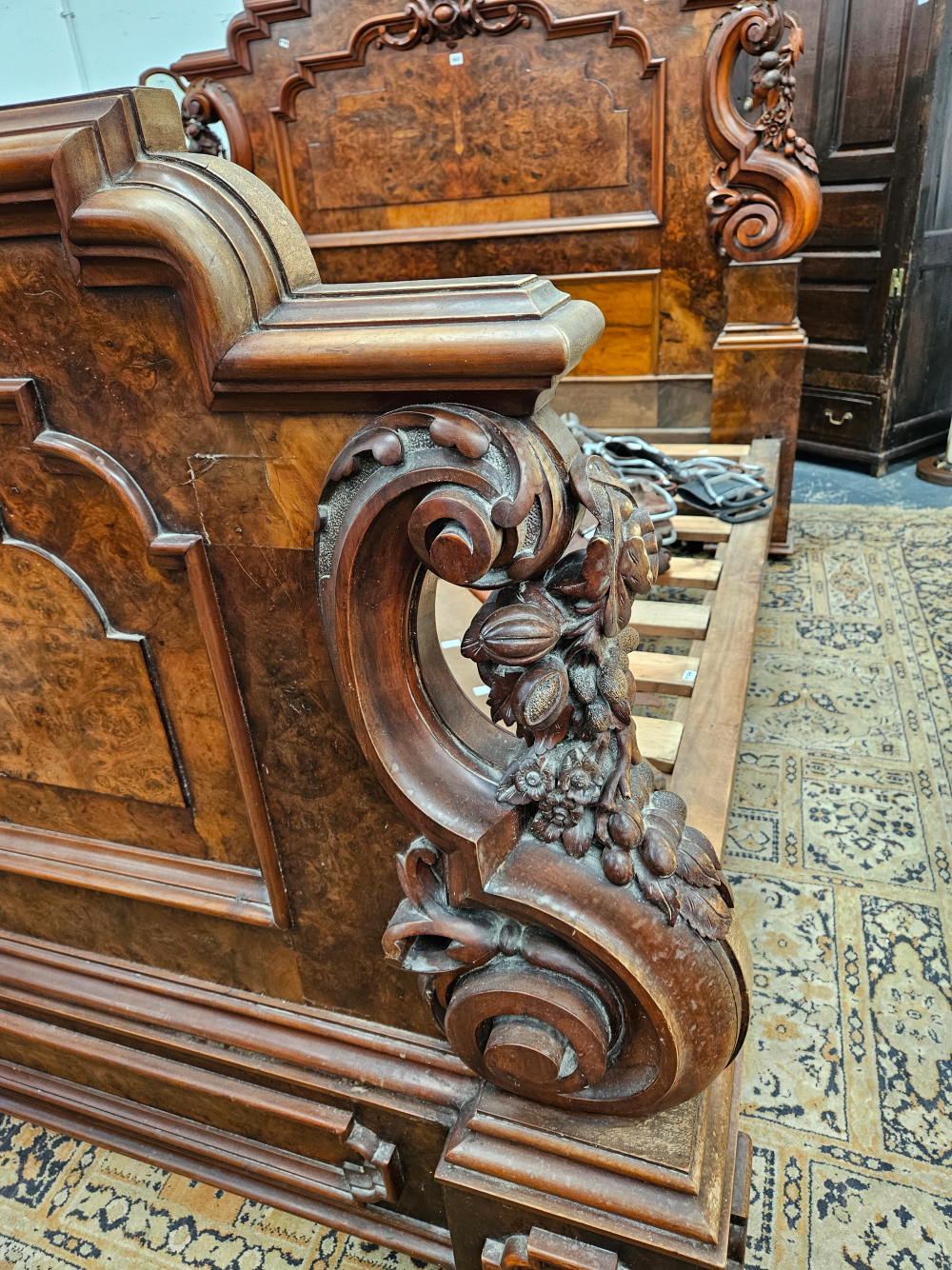 A LATE VICTORIAN BURR WALNUT DOUBLE BED WITH PANELLED ENDS FLANKED BY SCROLLING BRACKETS CARVED WITH - Image 8 of 8