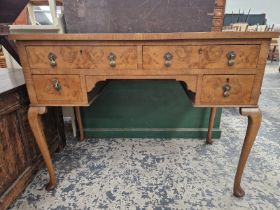 A 20th C. CROSS BANDED WALNUT FIVE DRAWER DRESSING TABLE ON CABRIOLE LEGS WITH CLUB FEET. W 99 x D