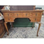 A 20th C. CROSS BANDED WALNUT FIVE DRAWER DRESSING TABLE ON CABRIOLE LEGS WITH CLUB FEET. W 99 x D