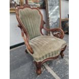 A VICTORIAN WALNUT SHOW FRAME ARMCHAIR CRESTED BY A PAIR OF CARVED FLOWER HEADS THE ARMS SUPPORTED