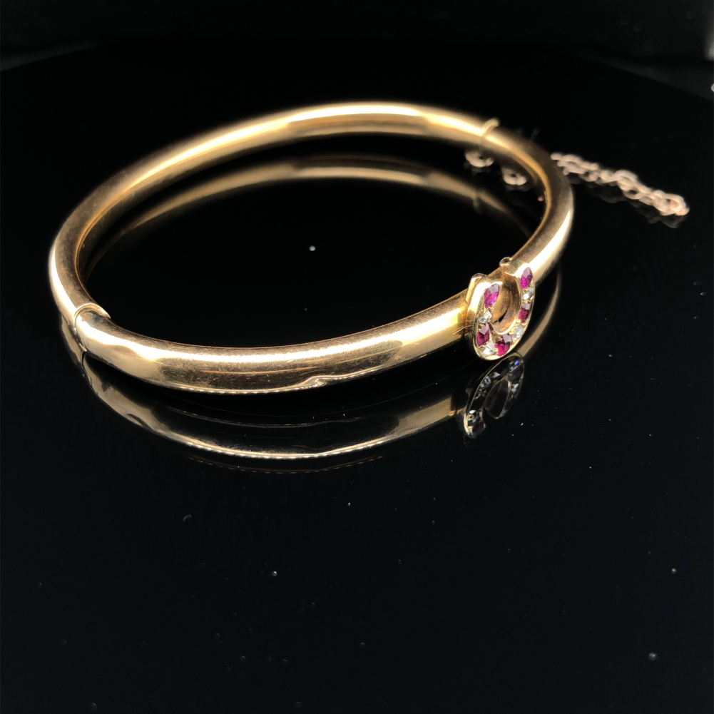 AN ANTIQUE BANGLE SET WITH A RUBY AND DIAMOND HORSESHOE. THE HINGED BANGLE UNHALLMARKED, ASSESSED AS - Image 4 of 8