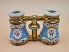 A LEATHER CASED PAIR OF OPERA GLASSES WITH JEWELLED AND FLOWER PAINTED BLUE GROUND ENAMEL BARRELS