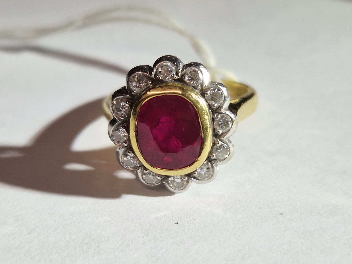 AN 18ct HALLMARKED GOLD RUBY AND DIAMOND OVAL SHAPED CLUSTER RING. THE SINGLE MEDIUM TO DARK - Image 15 of 20