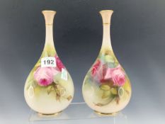 A PAIR OF EARLY 20th C. ROYAL WORCESTER BOTTLE VASES PAINTED WITH RED ROSES. H 21.5cms.