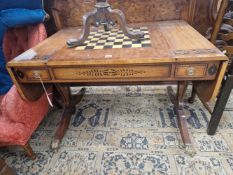 A MAHOGANY FLAP TOP GAMES TABLE DECORATED WITH AN EBONISED SCROLL BAND, THE CENTRE OF THE TOP